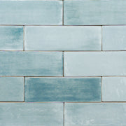 a group of 2x6.5 glossy aqua blue subway tiles with colour variation in a brick layout