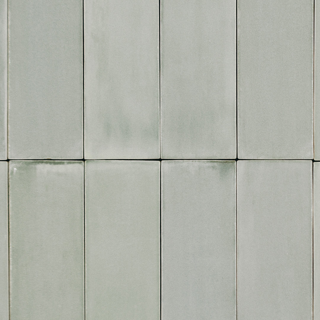 A stacked tile lay out featuring 2x6.5 seaglow bars; a glossy light coastal blue and aquamarine green tile with heavy colour variation. 