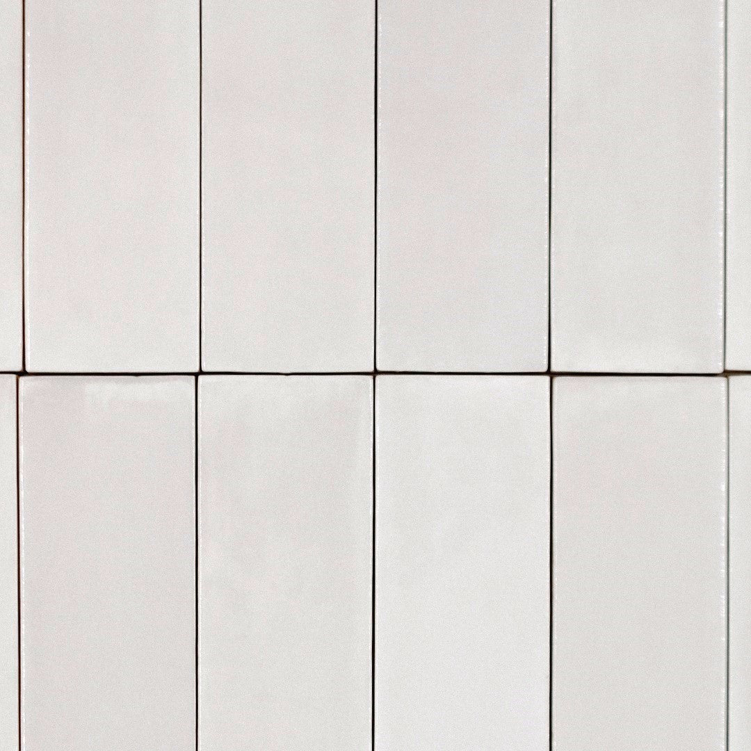 Ariel view of a stacked tile layout, the tiles are 2x6.5 glossy pearl subway tiles in an off-white coconut creamy grey with heavy colour variation. 