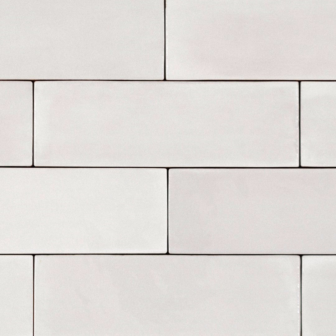 Ariel view of a brick tile layout, the tiles are 2x6.5 glossy pearl subway tiles in an off-white coconut creamy grey with heavy colour variation. 