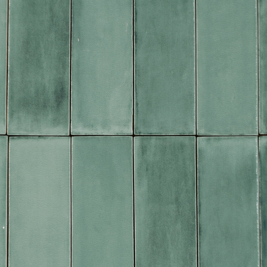 Ariel view of a stacked tile layout featuring bars brushed green, a glossy 2x6.5 dark green sage cool eucalyptus tile. 