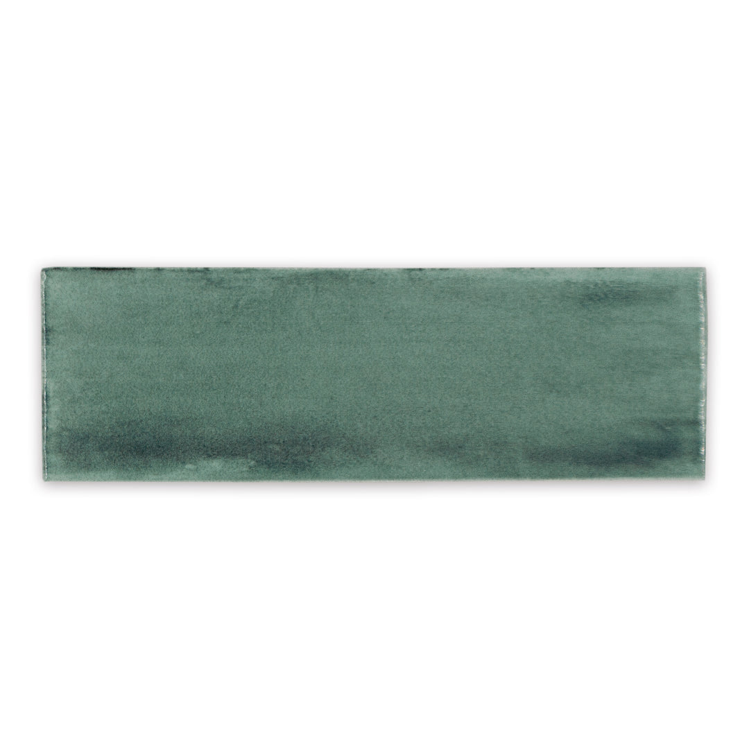 A single 2x6.5 dark eucalyptus brushed green bars glossy subway tile. 