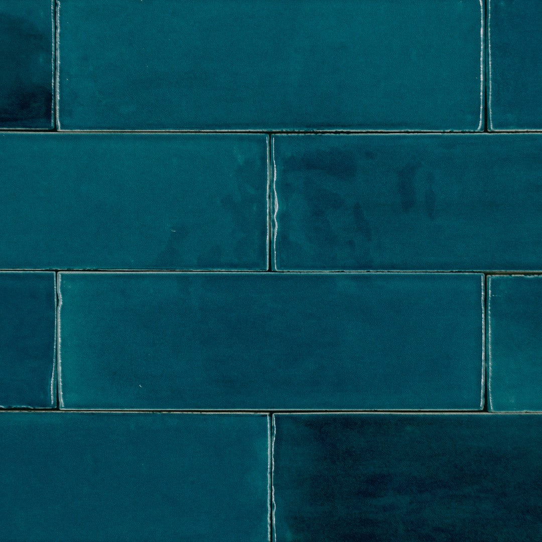 Ariel close up of 2x6.5 ocean bars in a brick layout; a glossy cobolt sapphire blue tile with heavy colour variation. 