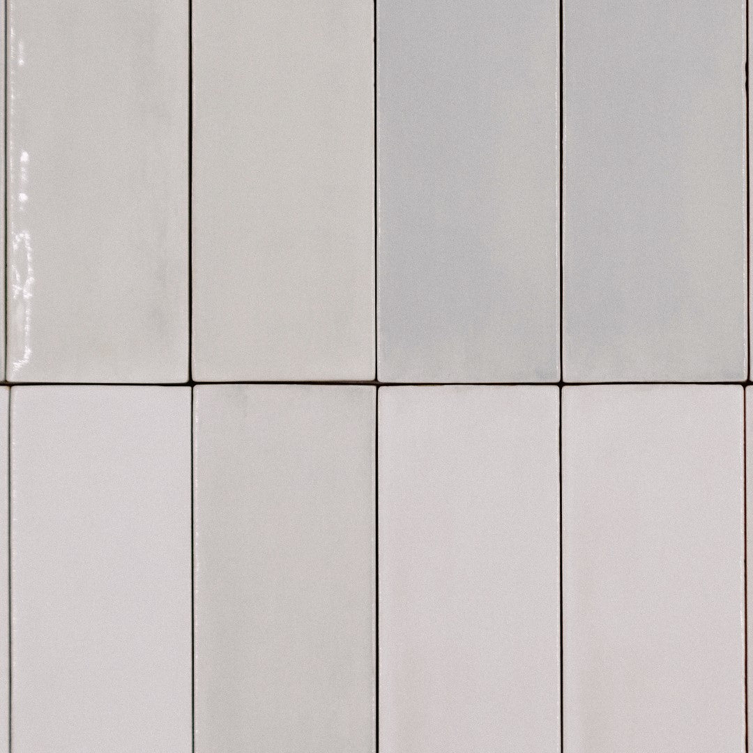 Ariel close up of a stacked tile layout, the tiles are 2x6.5 glossy salt subway tiles in a warm grey seashell light beige griege with heavy colour variation. 