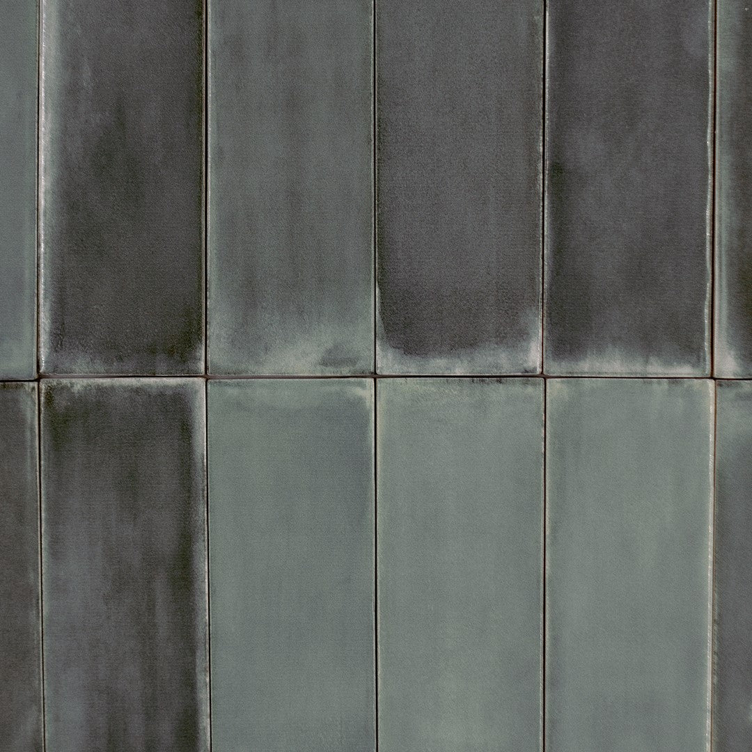 Ariel view of a stacked tile flat lay where the tiles are 2x6.5 glossy dark grey with heavy colour variation. 