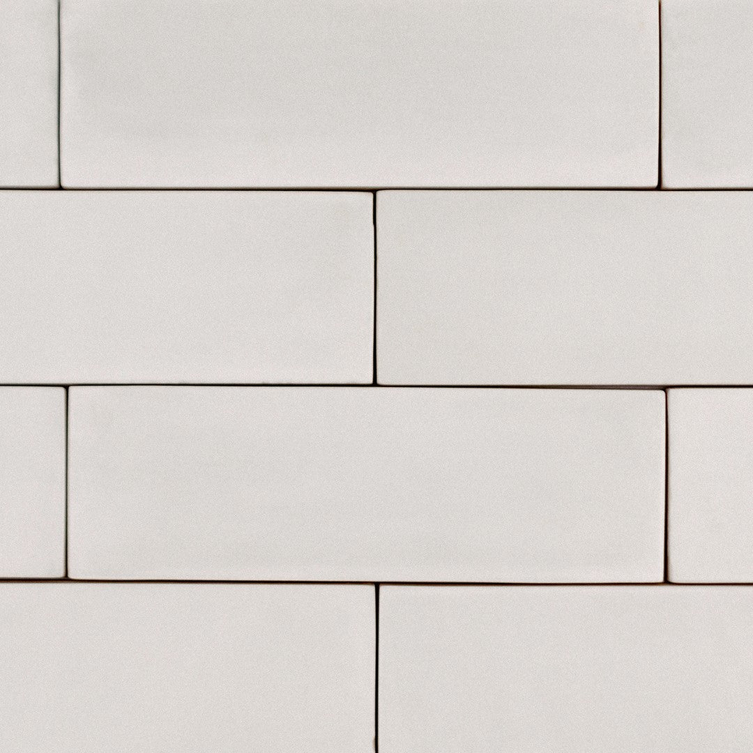 A brick tile layout featuring 2x6.5 milkstone bars; a matte off white cream tile with heavy colour variation. 
