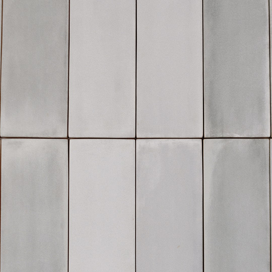 Ariel view of a group of 2x6.5 misty gray bars; a matte grey silver tile with heavy colour variation. 