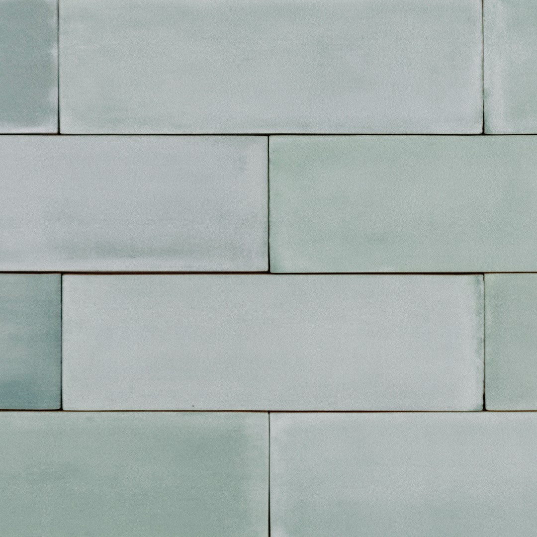 ariel view of a brick layout of 2x6.5 seaside bars; a matte light sage green tile with heavy colour variation. 