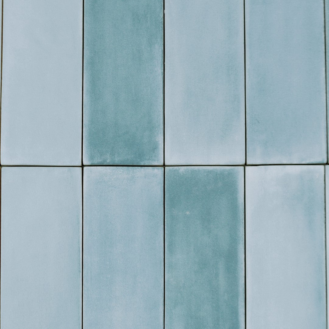 Ariel view of a group of stacked 2x6.5 aqua bars; a matte light tiffany watery blue turquoise tile with heavy colour variation. 