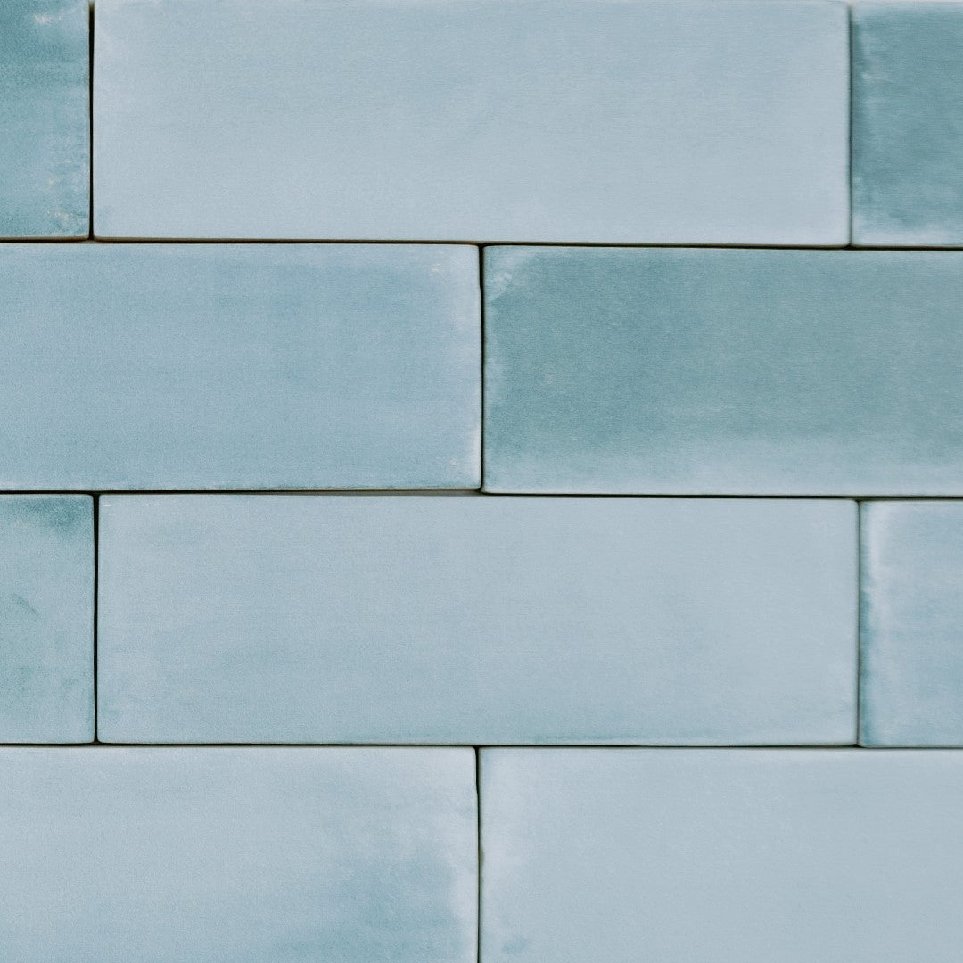 Ariel close up of a group of 2x6.5 aqua bars; a matte light tiffany watery blue turquoise tile with heavy colour variation. The tiles are in a brick layout to show off the shade variation. 