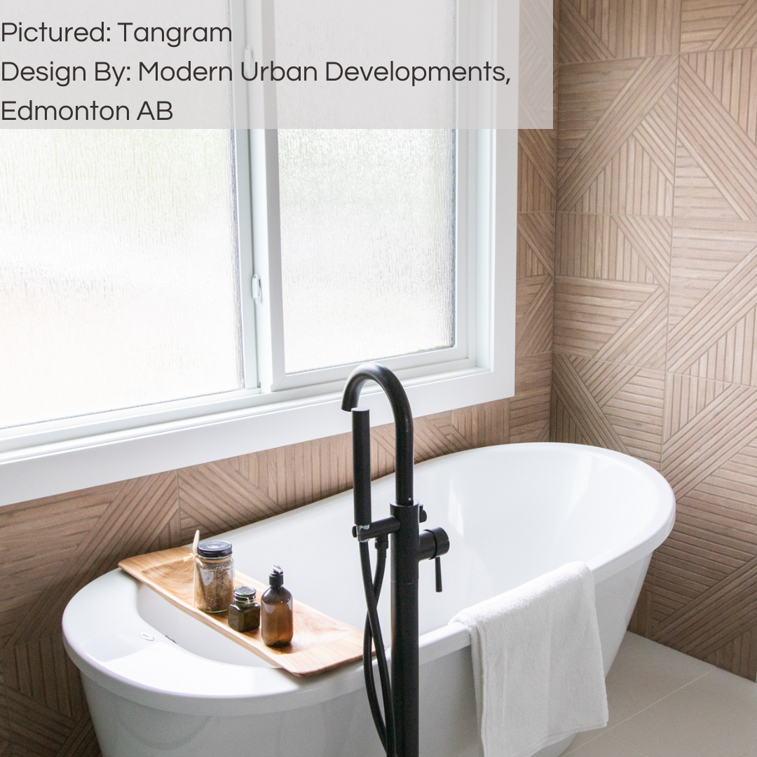 A spa like bathroom with a large whitefreestanding tub facing a big window. The walls of the room are covered in wood look tiles with a geometric modern pattern in a light brown oak colour. tangram oak