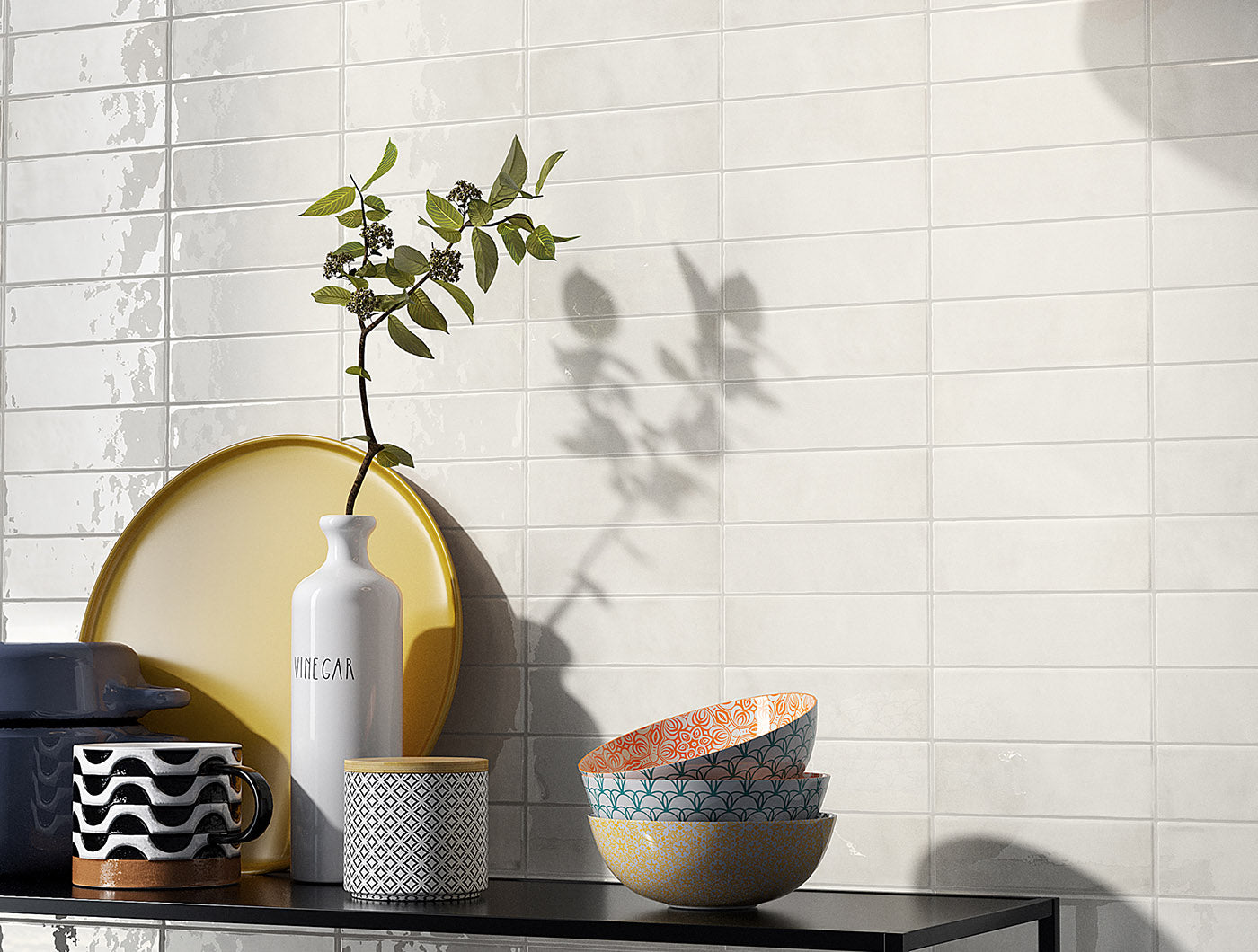 A modern tile vignette, the tiles are 2x6.5 glossy pearl subway tiles in an off-white coconut creamy grey with heavy colour variation. 