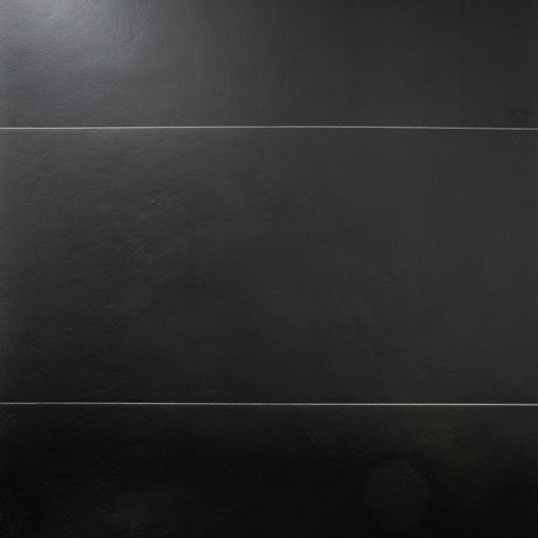 Ariel close up view of black 12x24 tile, checkmate black features a slight stone look, with subtle texture and a matte finish. 