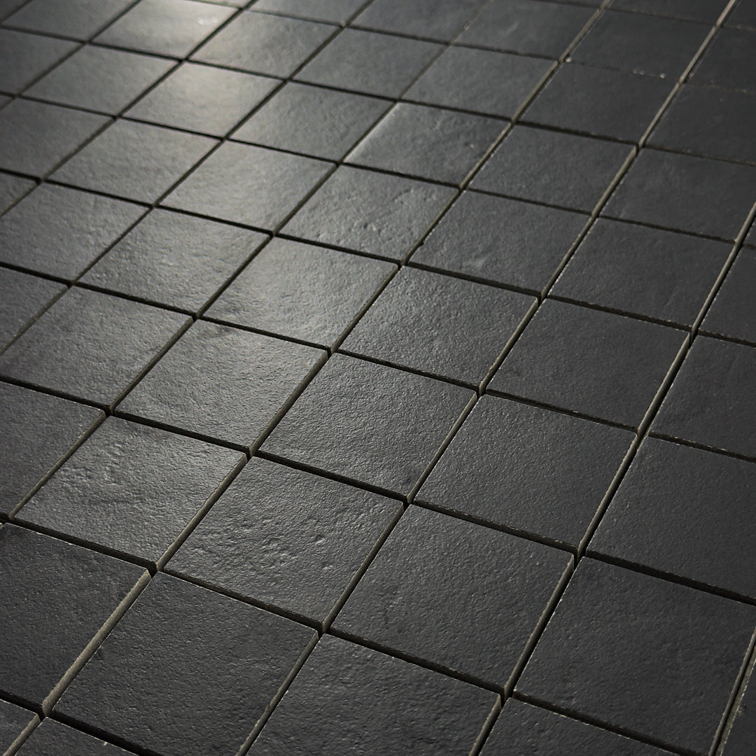 A close up detailed view of the 12x12 sheet mosaic tile made of 2x2 black stone look tiles with a subtle texture