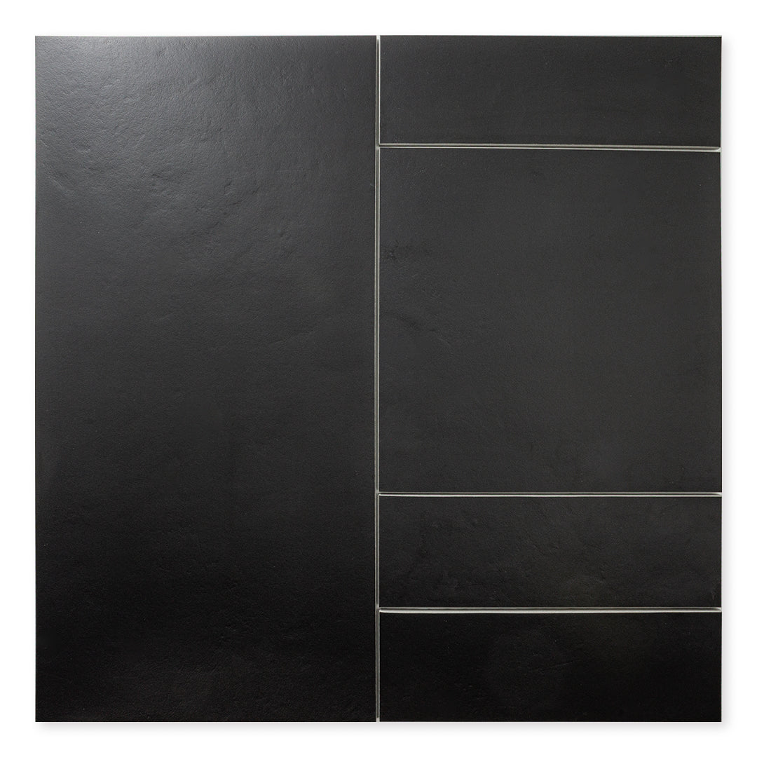 Multiple sizes of the black tile laid out to show the tiles together with a soft stone appearance and texture. 