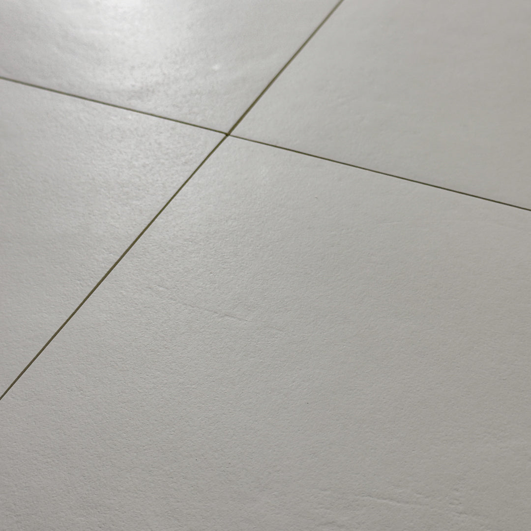 Grey 12x12 tiles in a close up view of four square tiles together with a soft stone appearance and texture. 