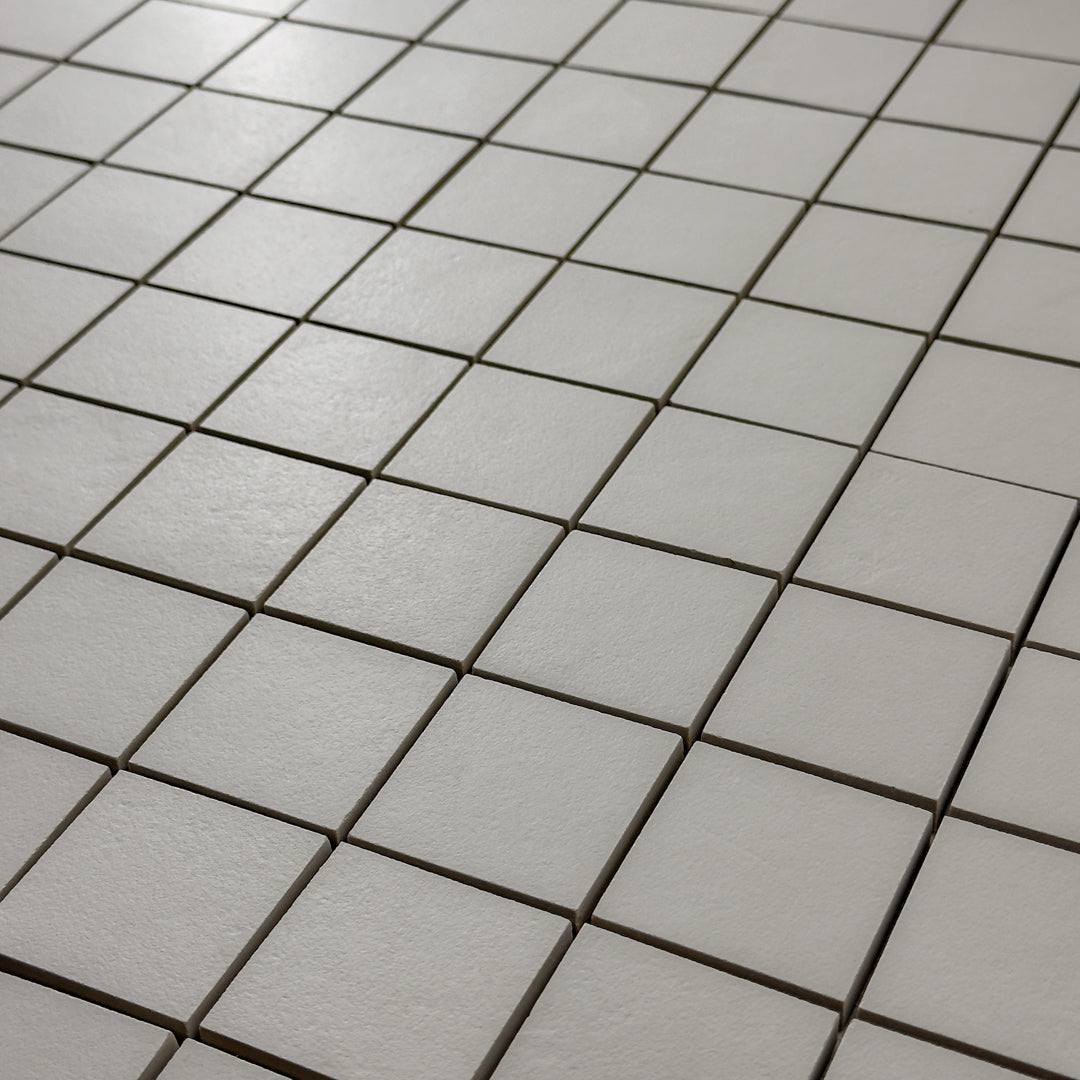 A close up detailed view of the 12x12 sheet mosaic tile made of 2x2 grey stone look tiles with a subtle texture