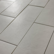 Close up photo of Grey 4x12 tile laid out in a vertical brick pattern with a soft stone appearance and texture. 