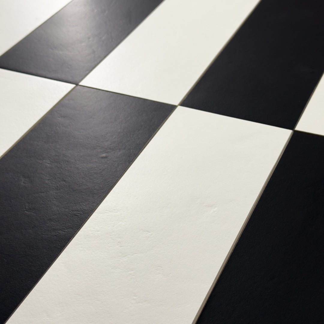 A close up view of Black 4x12 and White 4x12 tiles in a vertical stack reminiscent of piano keys, rectangular checkerboard pattern. 
