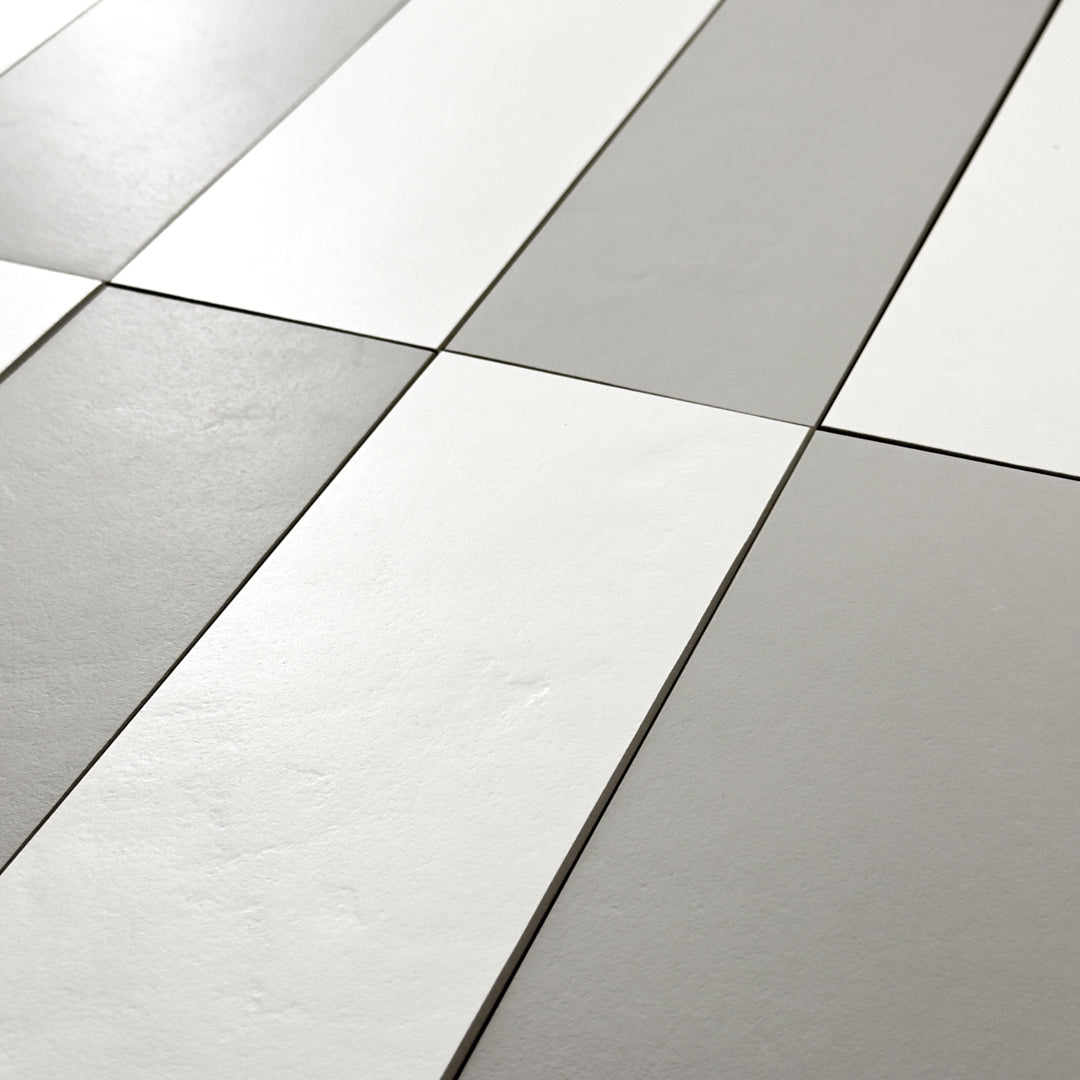 A close up view of Grey 4x12 and White 4x12 tiles in a vertical stack reminiscent of piano keys, rectangular checkerboard pattern. 