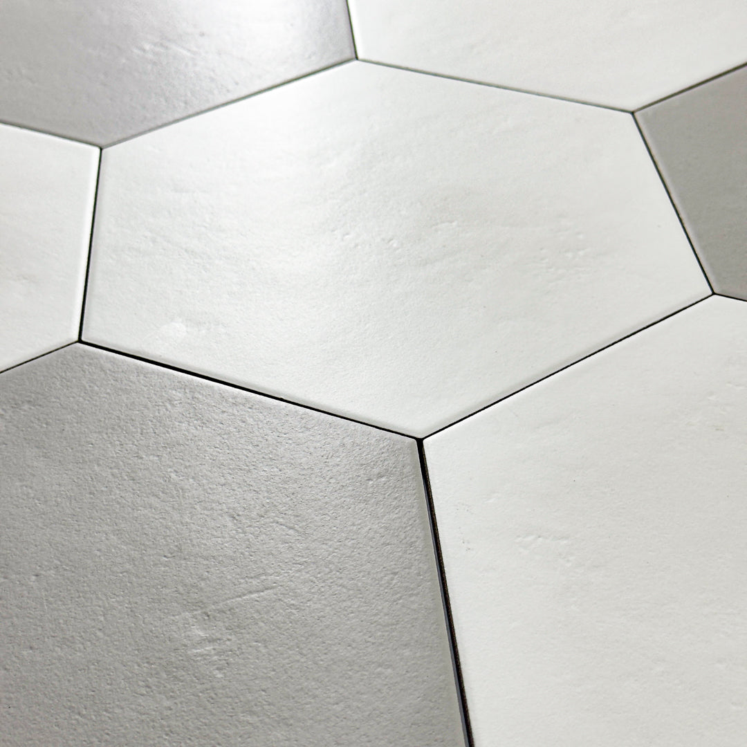 An close up view of 4 9x10 hexagon tiles mixed with white and grey tiles reminiscent of a traditional hexagon tile pattern.  