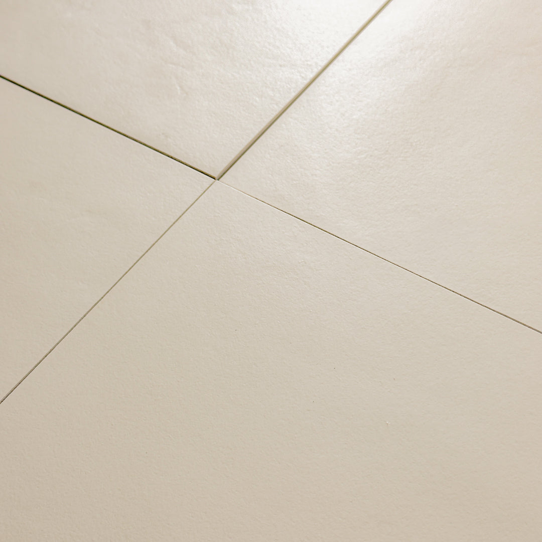 Beige 12x12 tile angled close up view of four square  tiles together with a soft stone appearance and texture. 