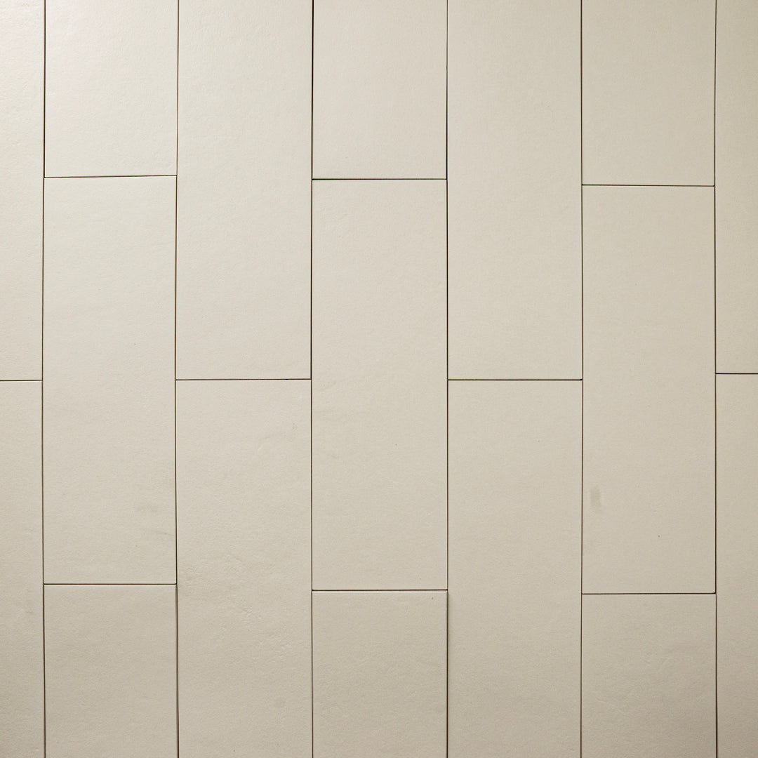 Beige 4x12 tile laid out in a vertical brick pattern with a soft stone appearance and texture. 