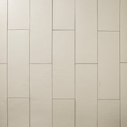 Beige 4x12 tile laid out in a vertical brick pattern with a soft stone appearance and texture. 
