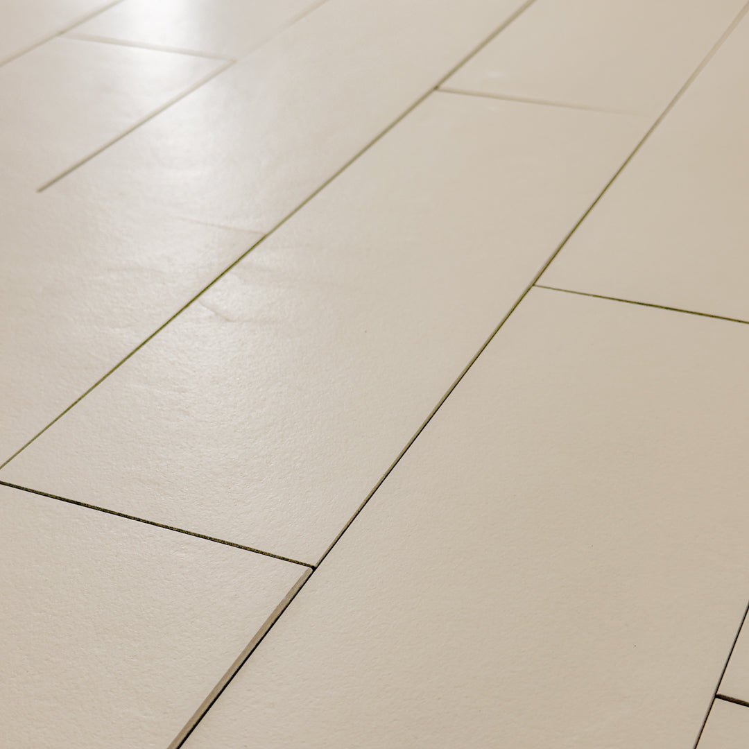 Close up photo of beige 4x12 tile laid out in a vertical brick pattern with a soft stone appearance and texture. 