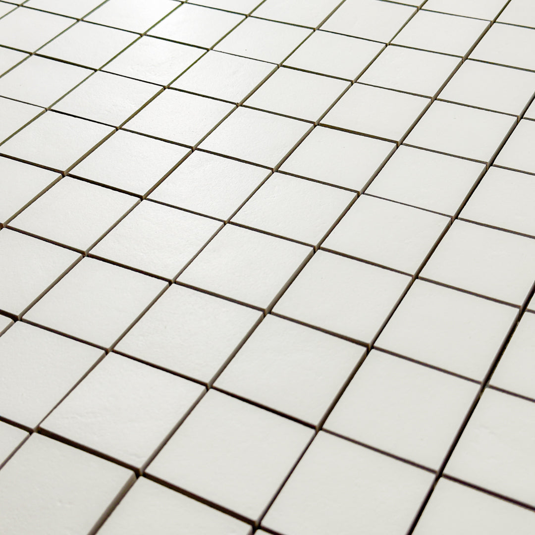 A close up detailed view of the 12x12 sheet mosaic tile made of 2x2 white stone look tiles with a subtle texture