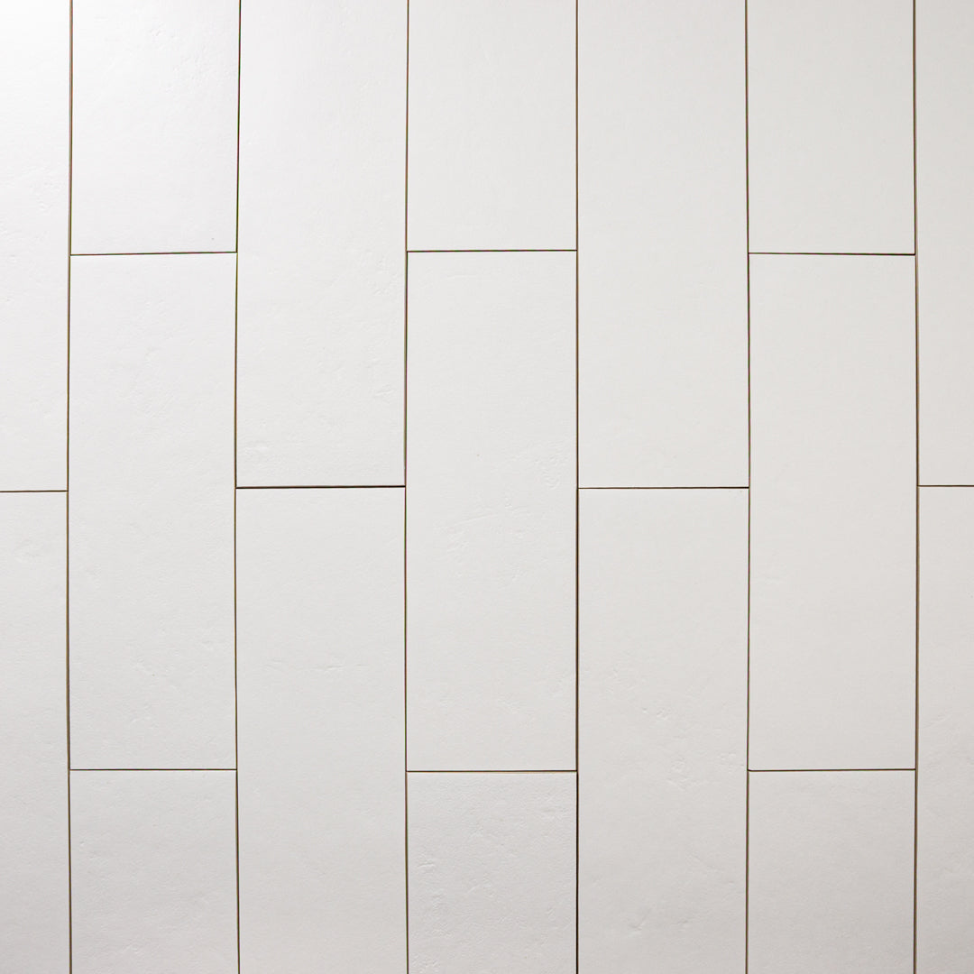 Ariel view of multiple White 4x12 tiles laid out in a vertical brick pattern with a soft stone appearance and texture. 