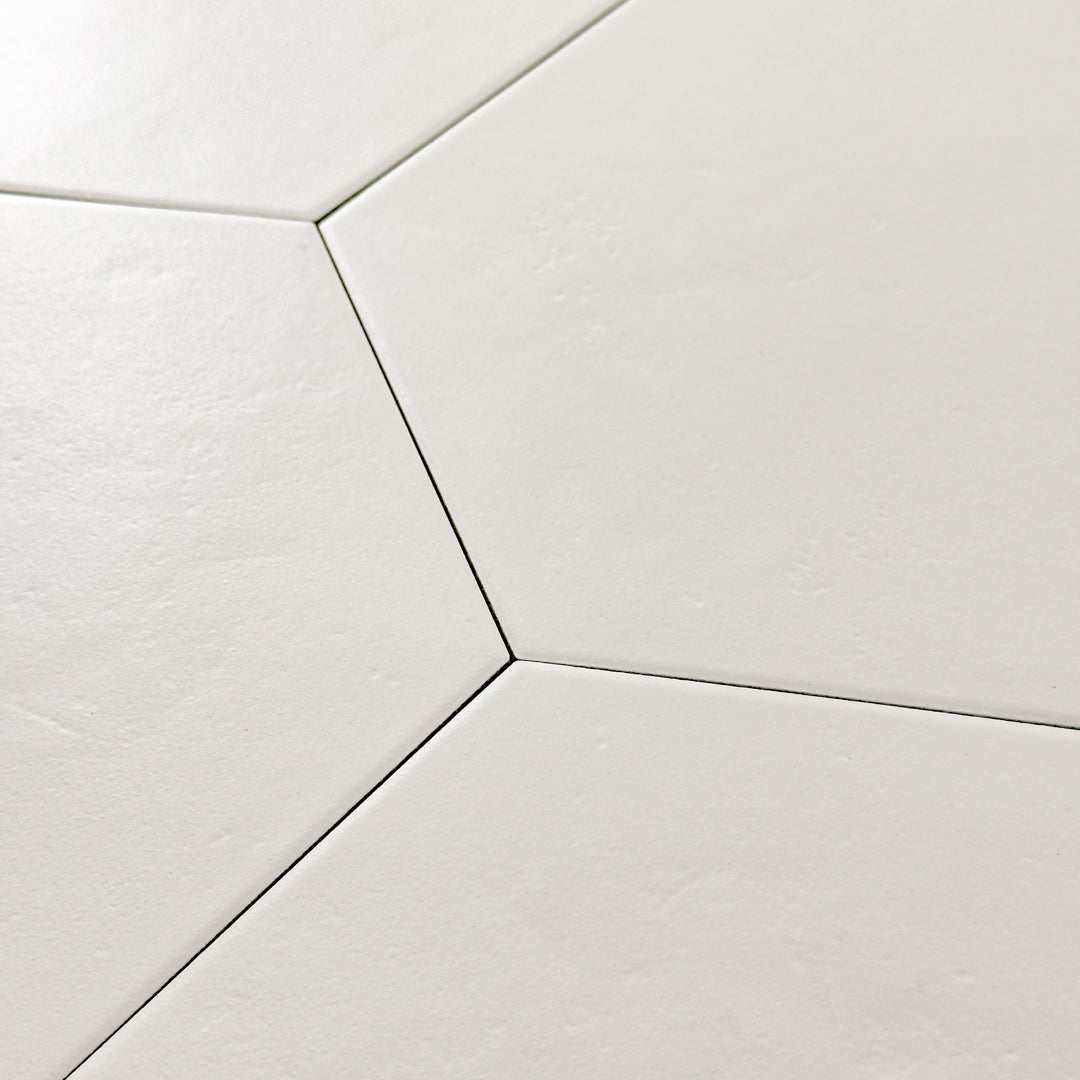 Angled close up view of four white 9x10 hexagon tiles, checkmate white features a slight stone look, with subtle texture and a matte finish. 