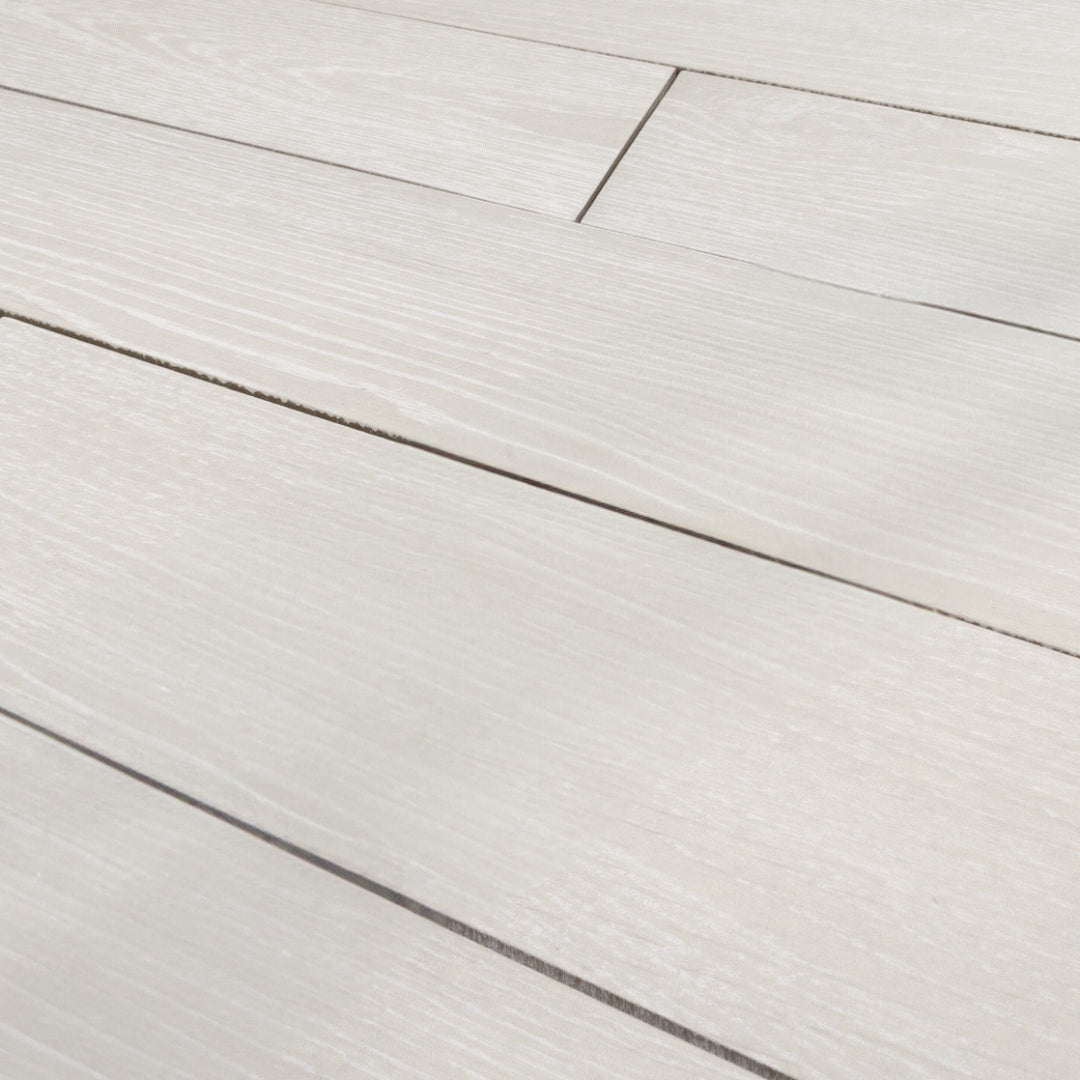 Angled Close up view of 4x20 chevron wood look tiles in white showing how the tiles line up together in a brick look. 