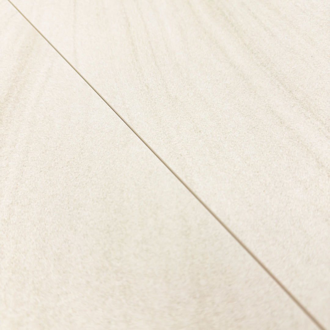 a close up of two tilesinspired solenne beige stone look rectangular tiles and where the meet to show the pattern doesn't exactly line up but it is so subtle that it flows anyways. 