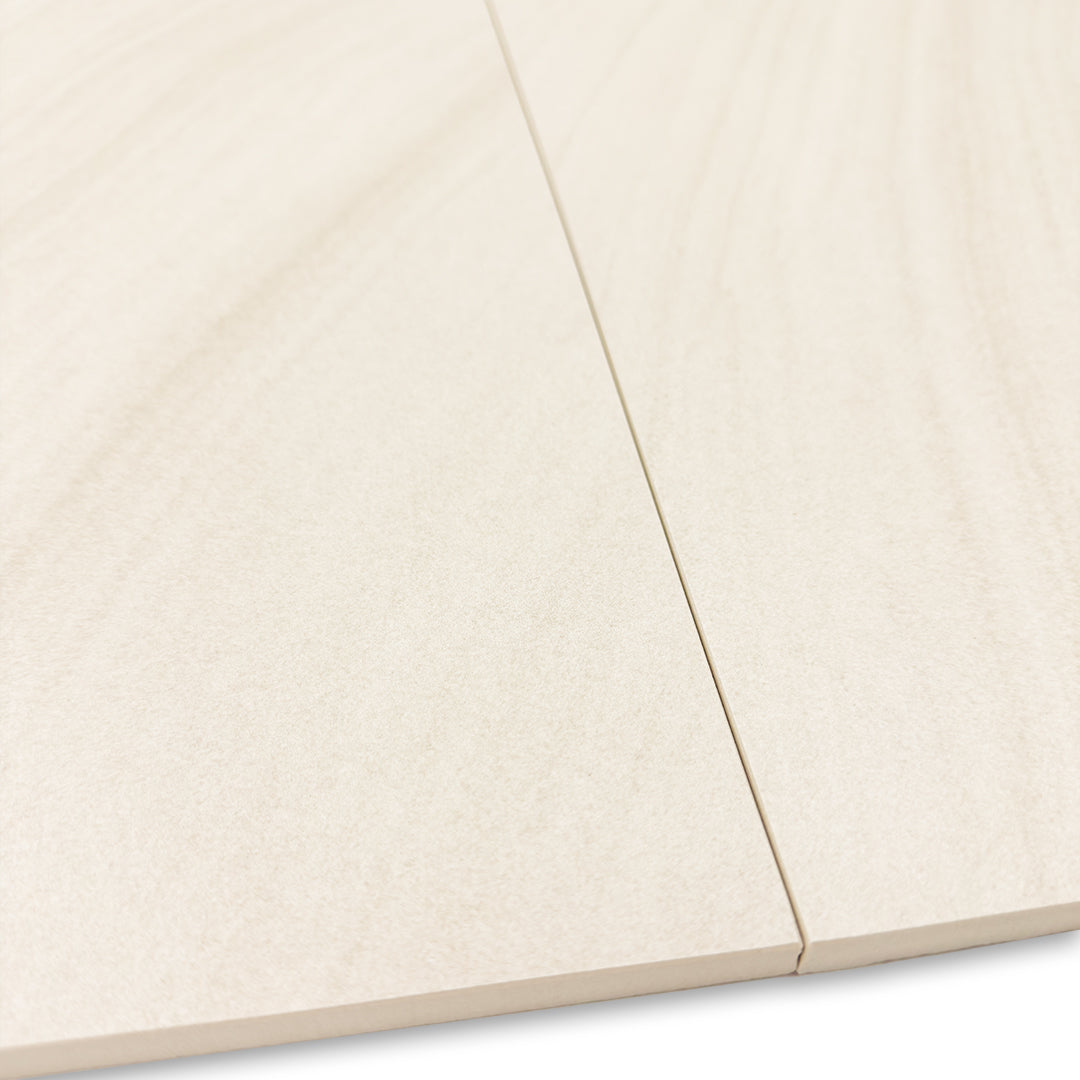 a close up of two tilesinspired solenne beige stone look rectangular tiles and where the meet to show the pattern doesn't exactly line up but it is so subtle that it flows anyways. this view shows the edges of the tiles