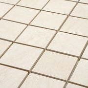 angled close up of a stone look 2x2 square mosaic in beige perfect for a shower floor, or niche accent. 