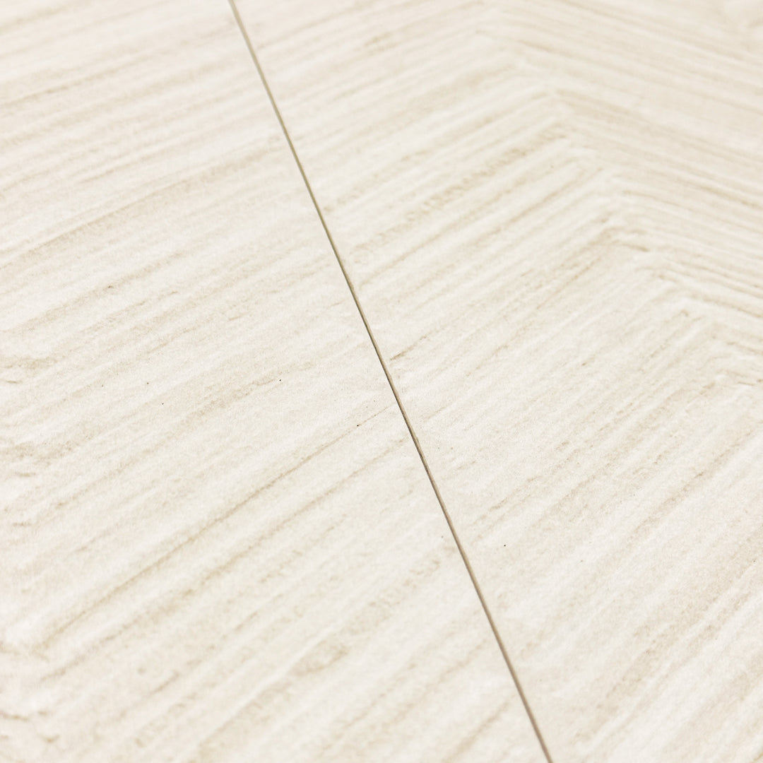angled view of two solenne beige structured tweed chevron look tiles showing off the pattern, colours and matte finish