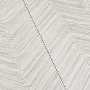Two side by side gray solenne chevron structured stone look rectangle large tiles. 