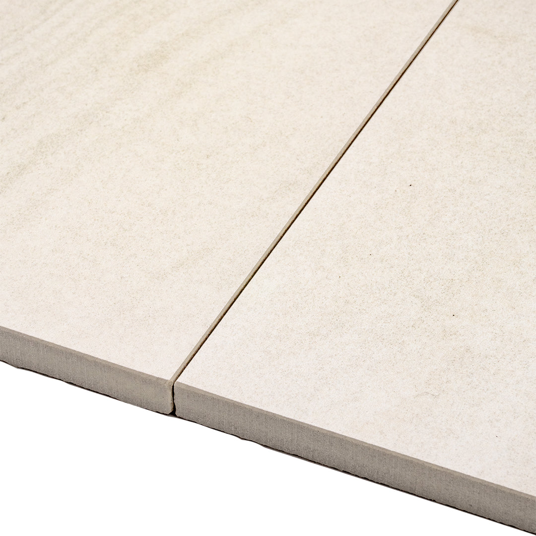 Angled close up of two solenne white stone look rectangle large tiles side by side to show the edge and pattern 