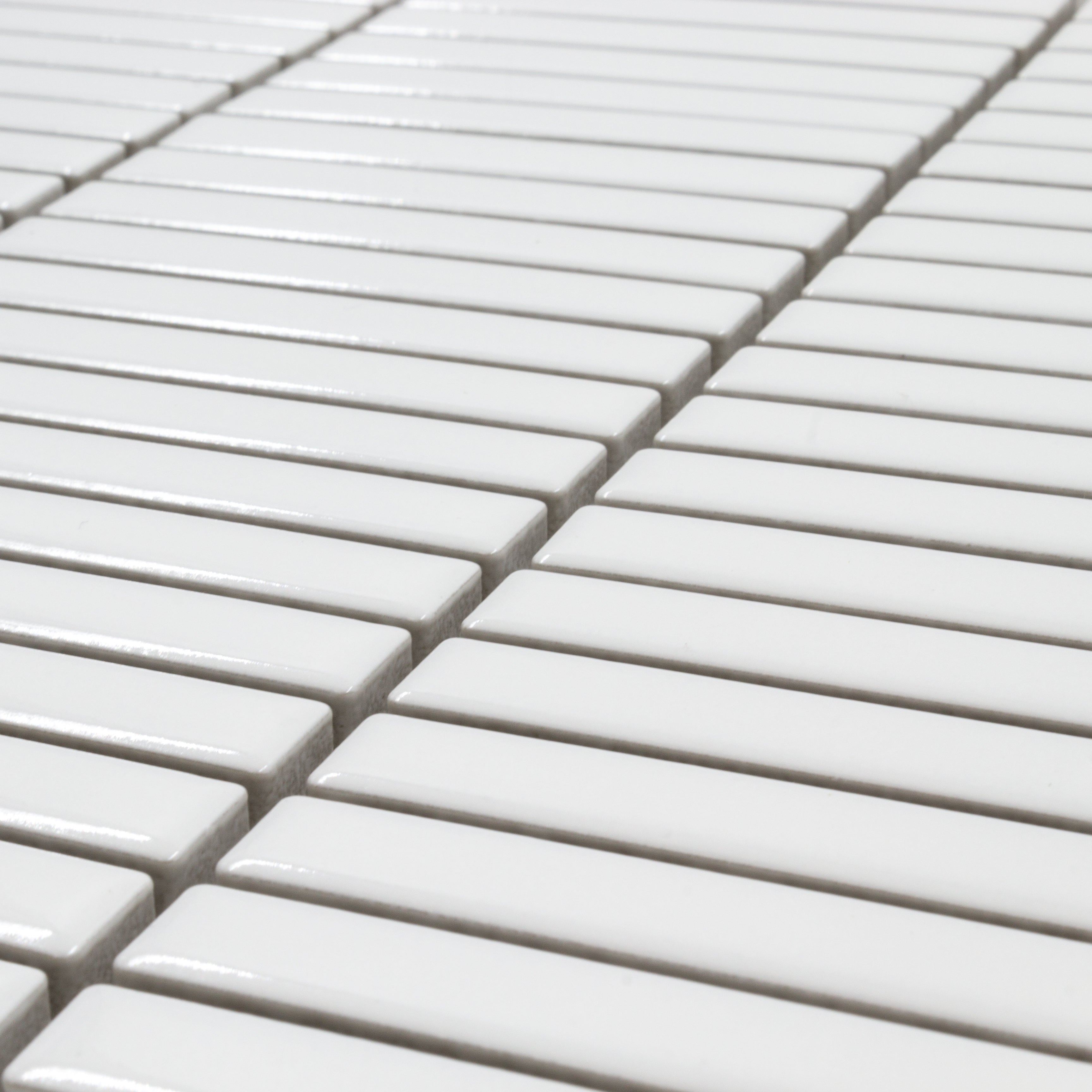 Angled close up view of a single sheet of mini kitkat stacked mosaic tiles in white glossy. The sizing is 3/8' x 3-5/8" per tile, 10.5" X 12" per sheet