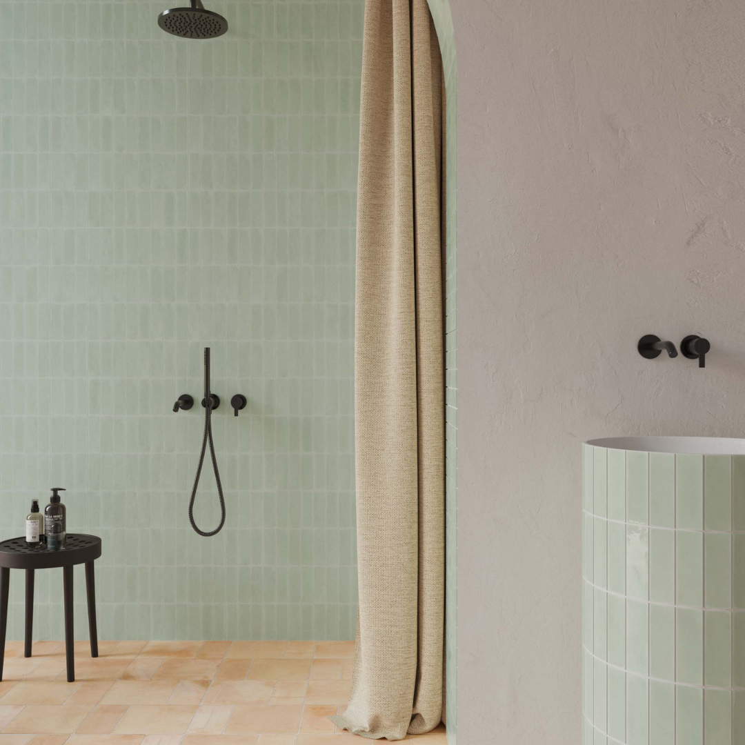 A rustic modern shower with lgith sage green subway 2x6 tiles. the tiles are installed in a vertical stack in the shower. 