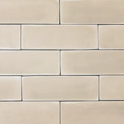 a group of beige 2x6 matte subway tiles with a soft texture and variance in a brick layout. 