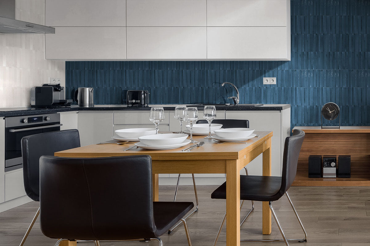 A minimalist modern kitchen with a feature wall backsplash. The striking tiles are 5x10 in glossy navy blue, the tile has a 3D linear faux grout line kitkat look. 
