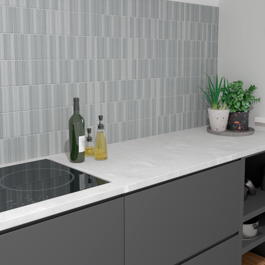 a modern kitchen with dark grey cabinets, white countertops and a fluted cool blue grey tile backsplash. the tiles are viva ash by tilesinspired
