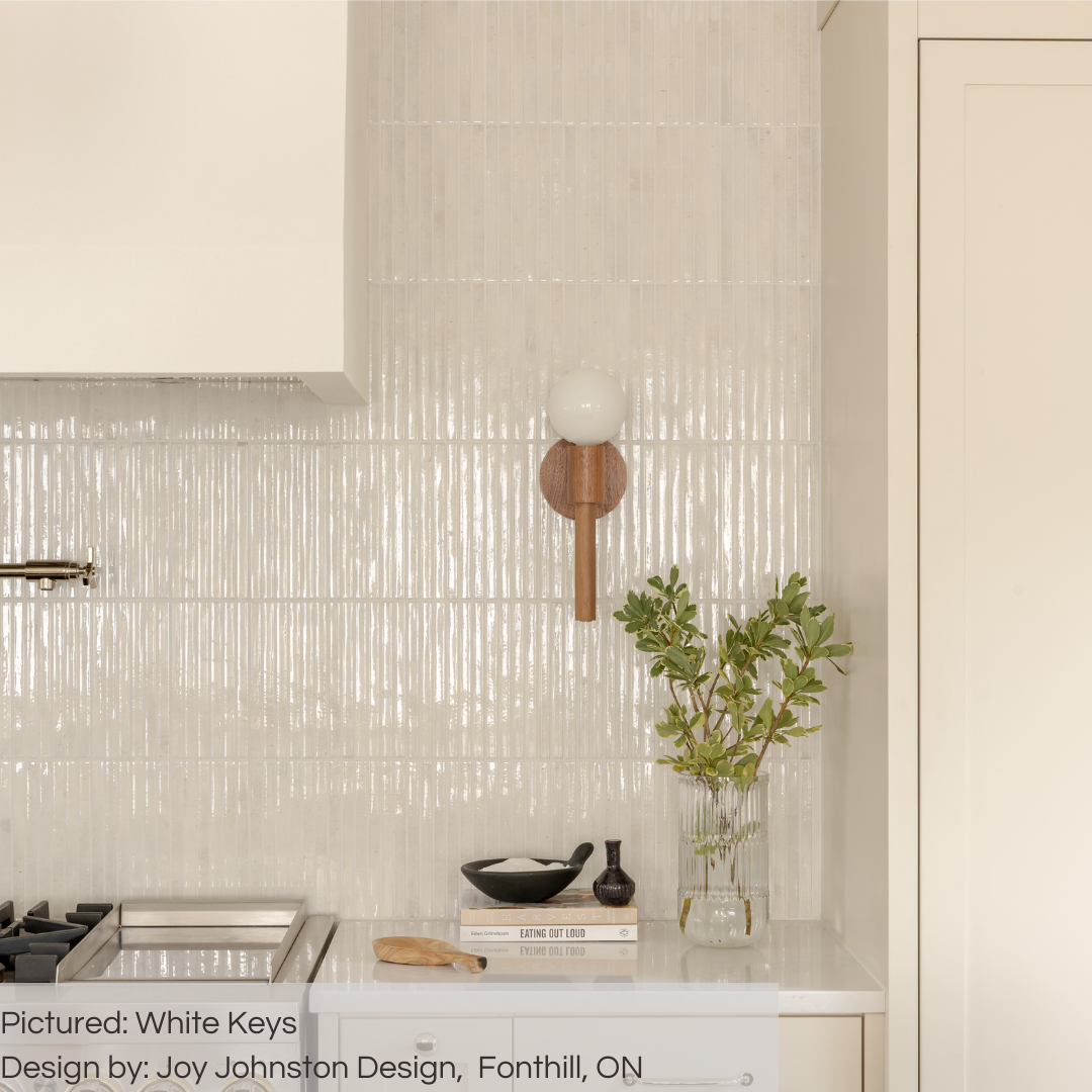 A close up of a kitchen backsplash with a gold pot filler and wood look sconces. The tiles are 5x10 panels in glossy milk white, the tile has a 3D linear faux grout line kitkat look and colour variation. 