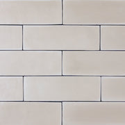 a group of taupe 2x6 matte subway tiles with a soft texture and variance in a brick layout. 