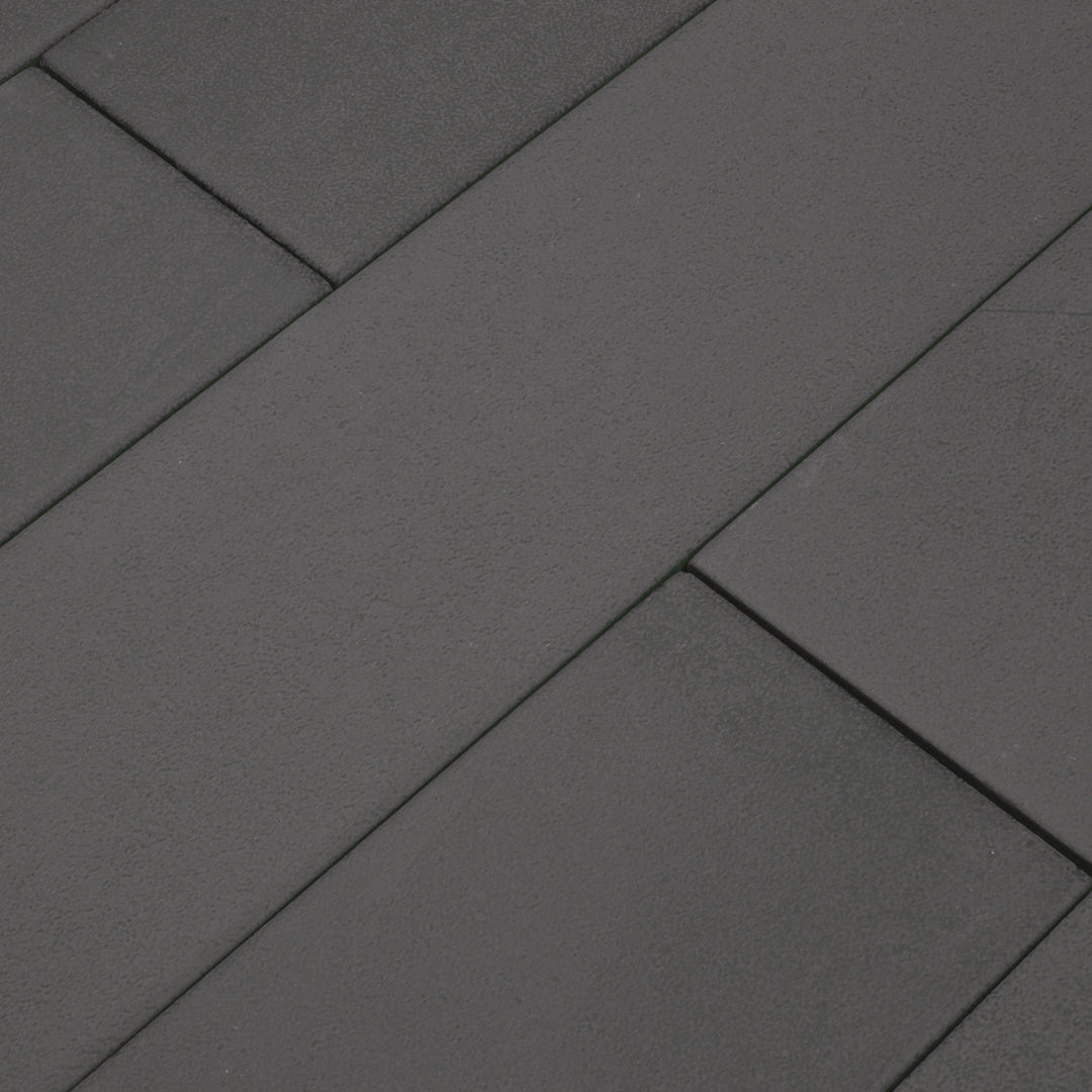 Ariel angled view of a group of dark grey 17.5" X 3.25" plank look tiles with subtle texture and pattern for floors or walls. 