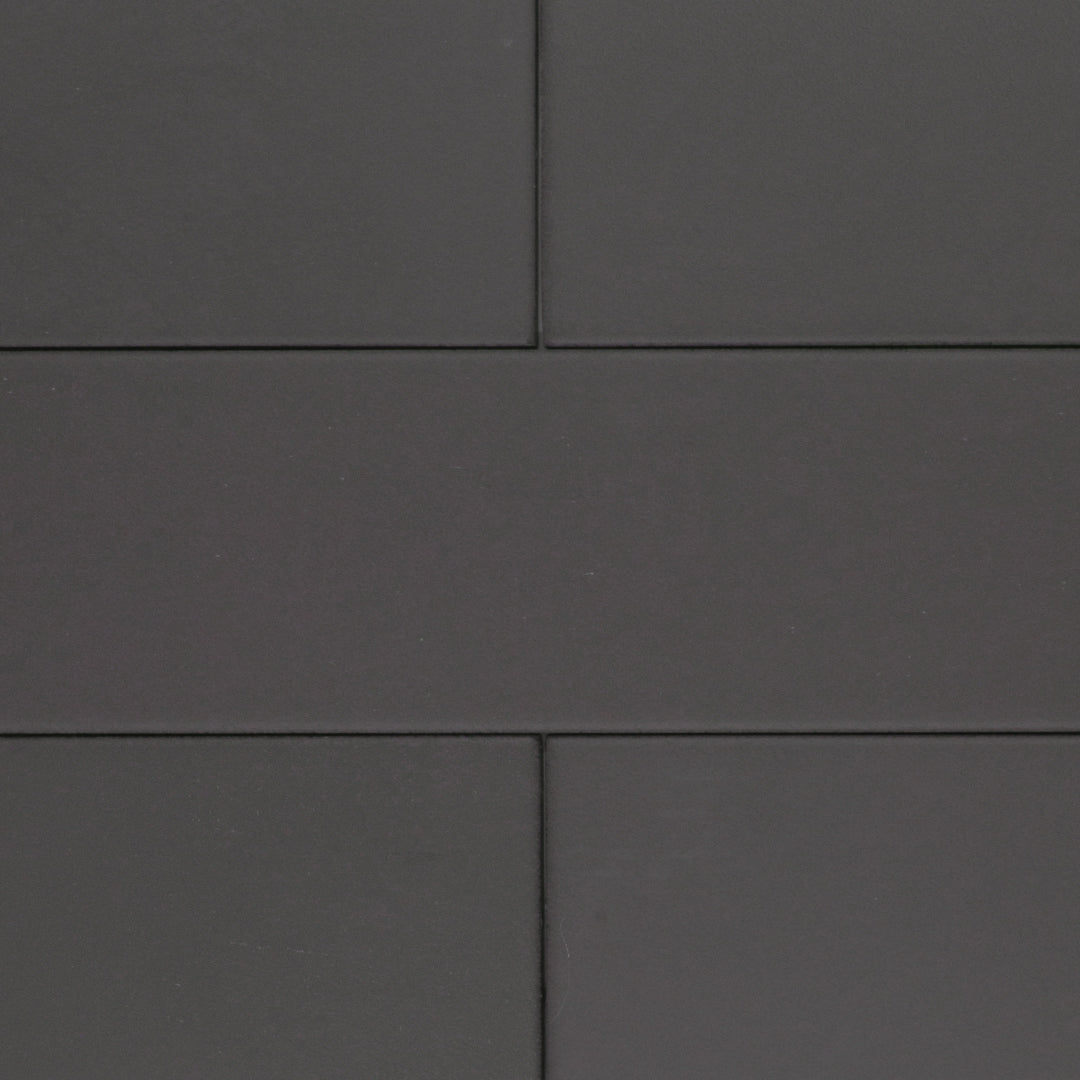 A group of charcoal black 17.5" X 3.25" plank look tiles with subtle texture and pattern for floors or walls. 