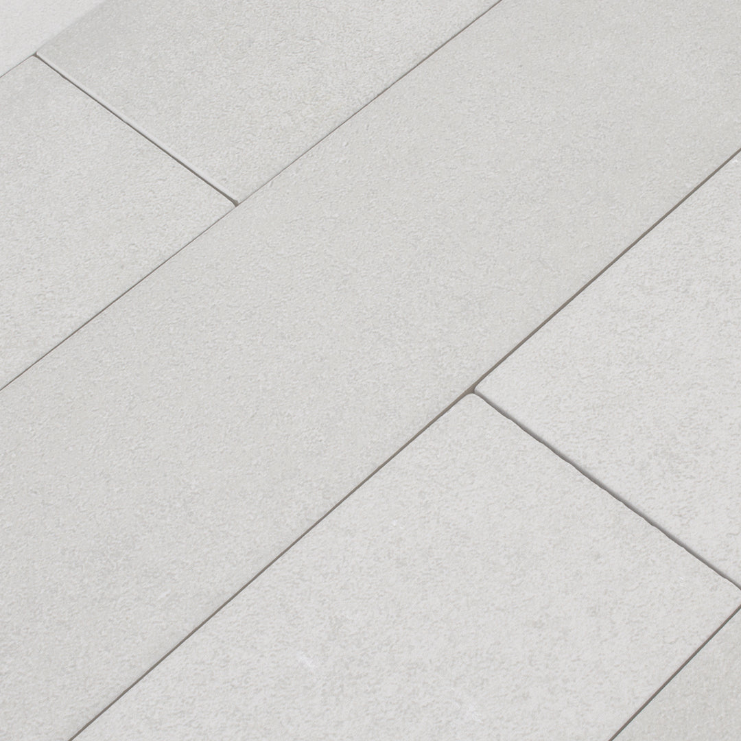 A group of smokey grey 17.5" X 3.25" plank look tile with subtle texture and pattern for floors or walls. 