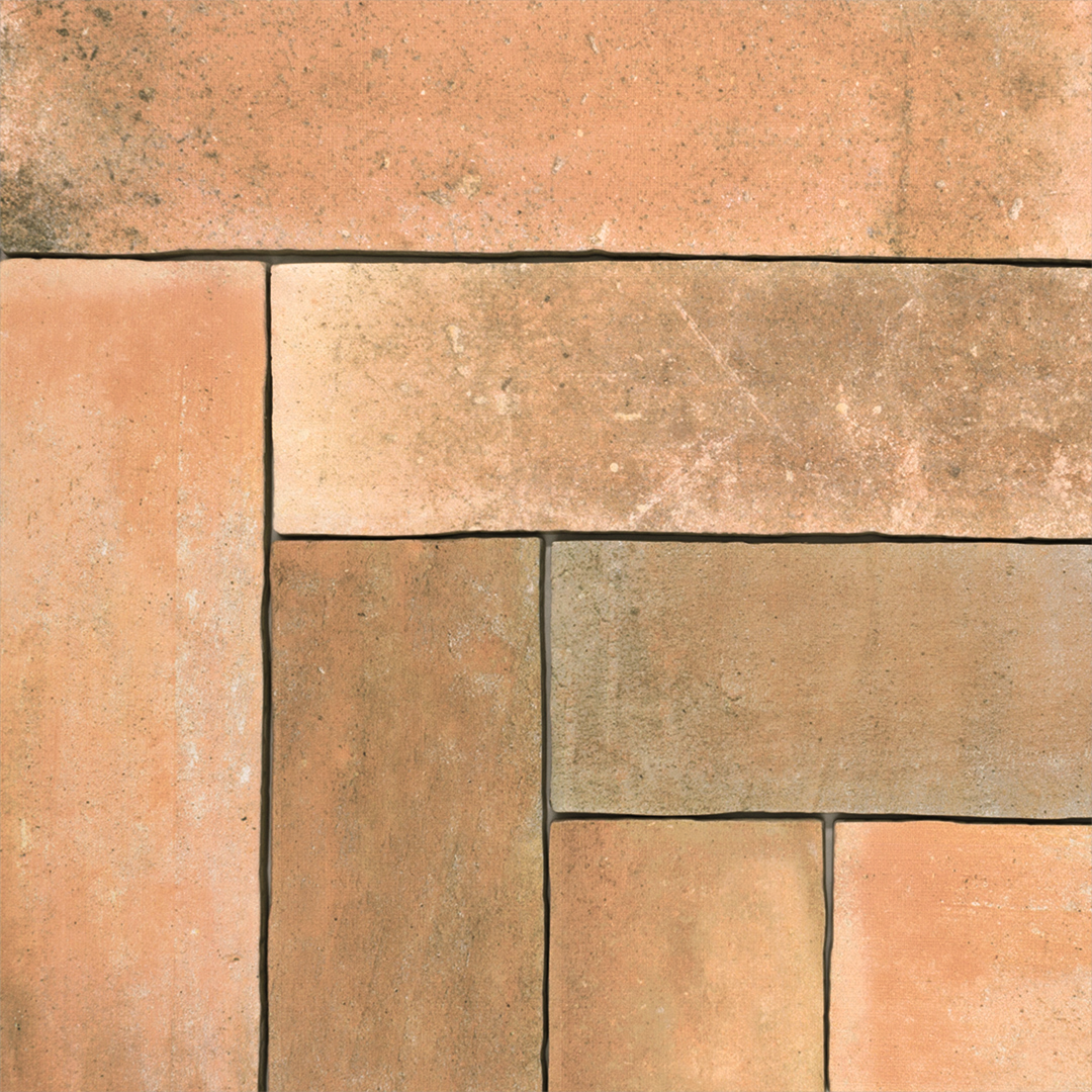 A group 11x2.75 brick clay terracotta stone look tile with heavy colour variations and a natural vibe laid out in a herringbone position to highlight the edges